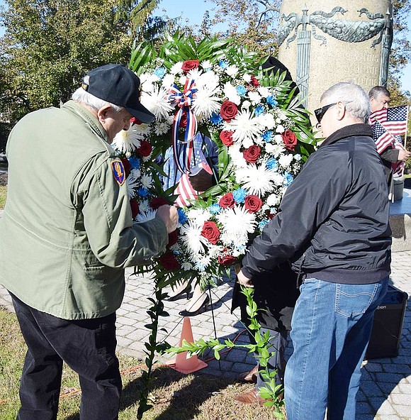 Veterans Dominick Mancuso and Pat Barrese place a memorial wreath at the flagpole monument recognizing local veterans who died during World War II and the Korean War, with a special memorial for the 8 Willow Street Boys who gave their lives in WWII.