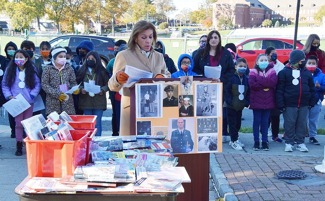 Principal Rosa Taylor makes opening remarks at the Park Avenue School Veterans Day ceremony in front of the school on Friday, Nov. 5. Pictures of veterans related to students as well as books about veterans and American wars donated to the school by retired Port Chester Middle School teachers Hank and Isabelle Birdsall in memory of local veterans who died during the past two years are on display.