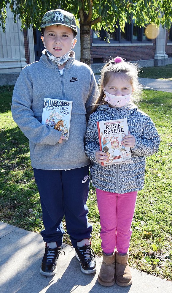 Park Avenue School fourth-grader John Giordano and kindergartner Gabriella Giordano each picked up a book to take back to their classroom from among those that were donated by Hank and Isabelle Birdsall.