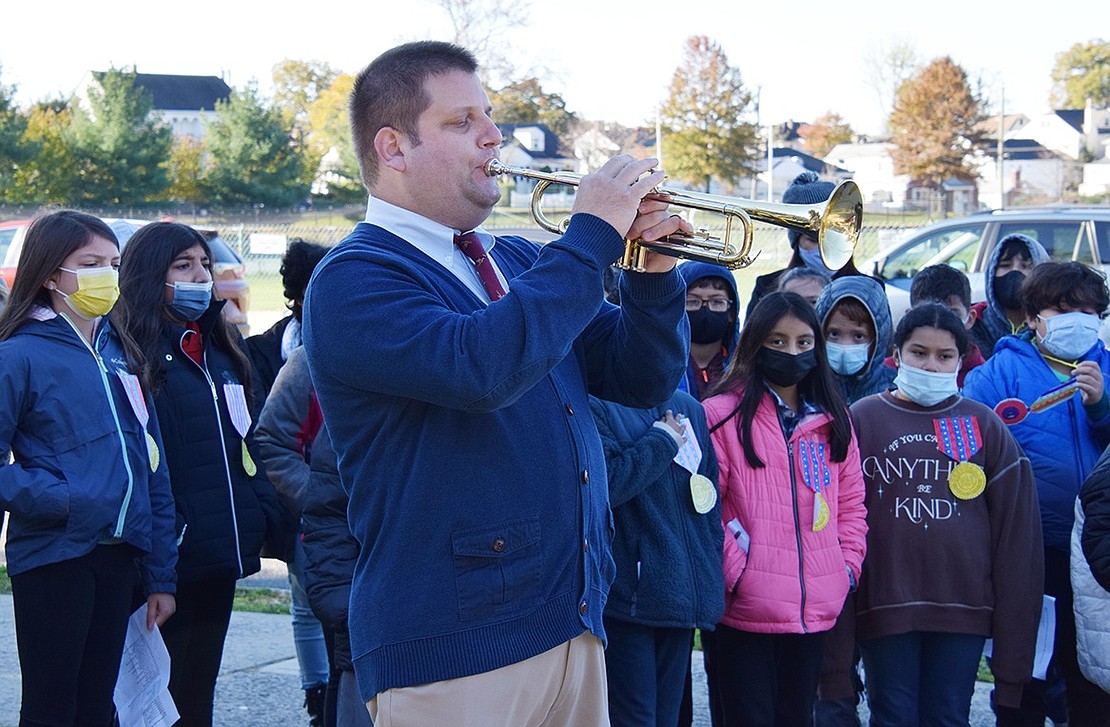 Park Avenue School instrumental music teacher Michael Johnson plays Taps on the trumpet in memory of veterans who have died.
