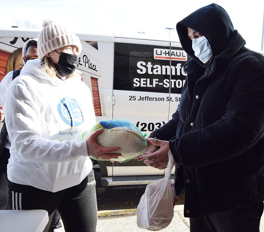 Chris Johnson of Drew Street accepts a turkey from Kate Howard, co-founder of The Giver’s Hand, in front of the long-closed Key Food supermarket on Midland Avenue on Saturday, Nov. 21. This is the second year the non-profit, formed in 2018, gave away turkeys ahead of Thanksgiving in Port Chester. They had 150 birds to distribute which had been donated by Costco in Port Chester and Wegmans in Harrison.