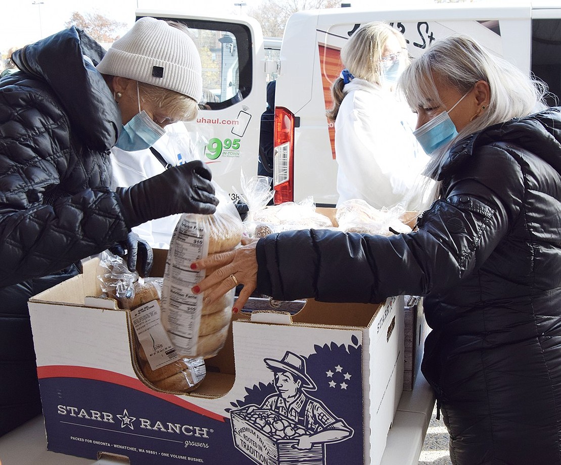 Francisca Arita of 29 Midland Ave. picks up bagels from The Giver’s Hand volunteer Vera Wethington, a longtime Rye Brook resident who now lives in Greenwich. They were also donated by Costco.