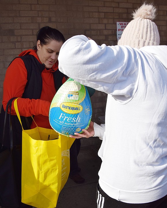 Kate Howard plops a fresh Butterball into Jennifer Arbusto’s bright yellow bag. Arbusto lives on Weber Drive. 