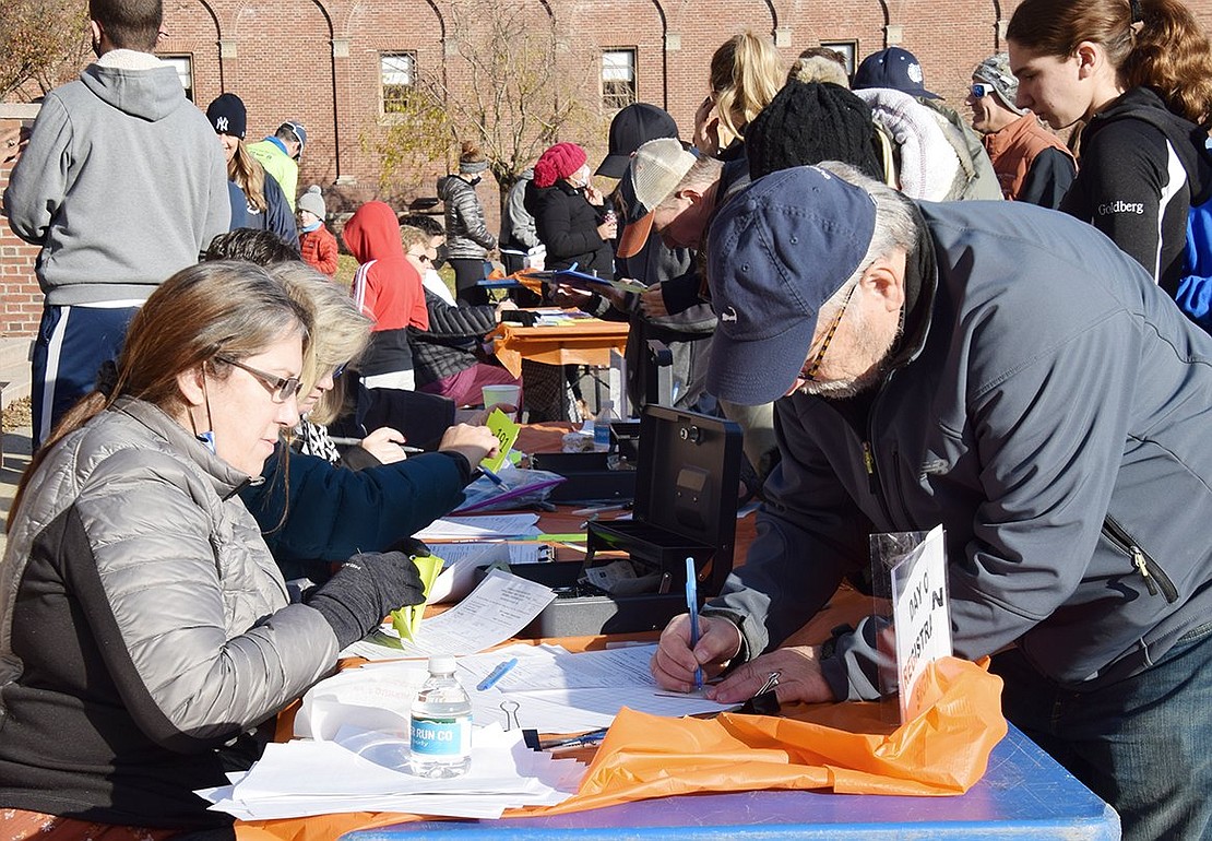 Many of the almost 300 people who participated in the Turkey Trot signed up the day of the run/walk, including Ted Darash of Puritan Drive. TTF volunteer Renée Carlucci helps him with the registration process. Liz Rotfeld chaired the event for the first time this year.