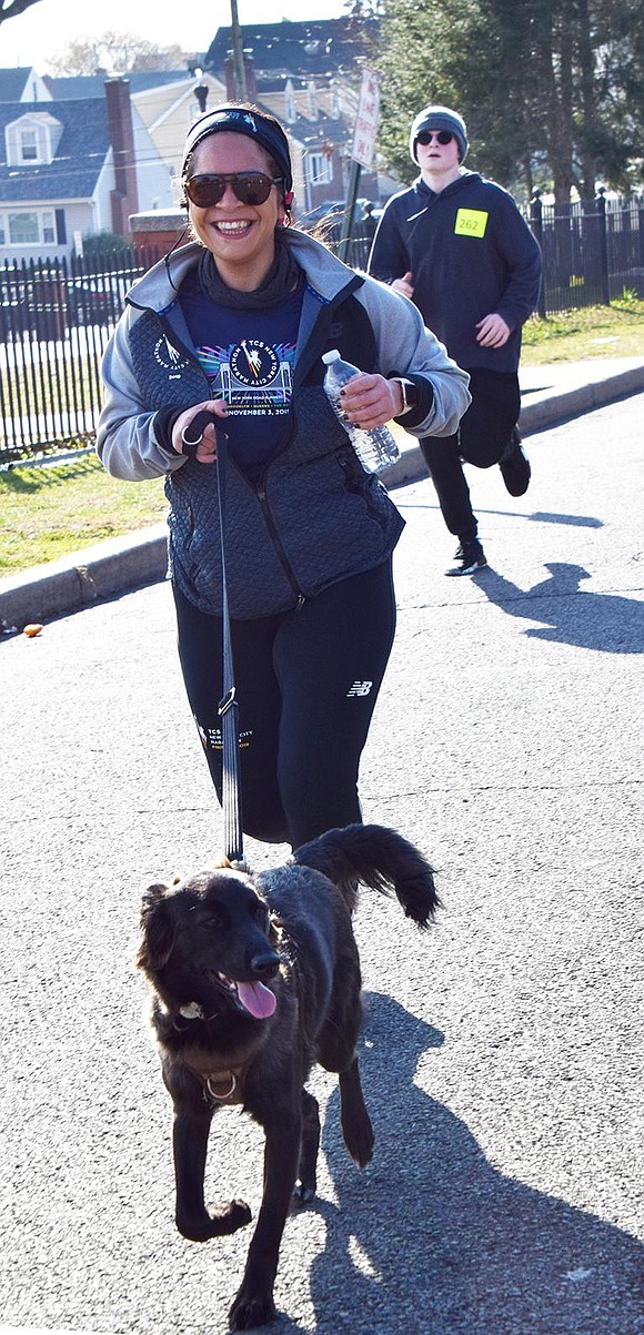 Omaris Valencia of Willett Avenue runs with her dog Andy which she rescued from Russia, one of many dogs in the race.