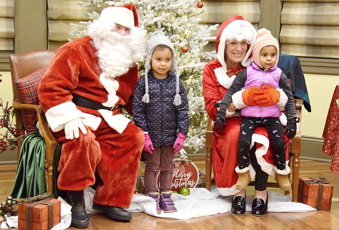 After waiting in a long line for a chance to meet Mr. and Mrs. Claus (also known as Peter Jackson and Rye Town Clerk Hope Vespia), Port Chester sisters Eli, 4, and Lucie Cadek, 2, take a break from chatting to gaze into the camera for a photo at the Rye Town Holiday Lights festival at Crawford Park on Saturday, Dec. 4.