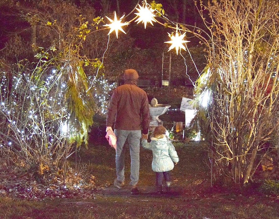 Talcott Woods, Rye Brook, resident Alvaro Larrain and his 2-year-old daughter Elysa walk hand-in-hand as they enter a festively decorated garden on the grounds to go for a magical stroll.