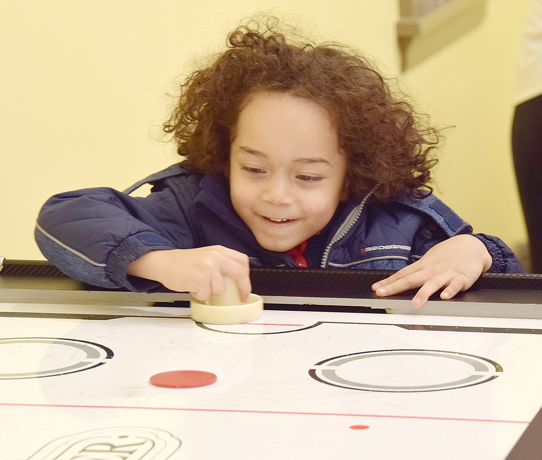 Win or lose, East Broadway, Port Chester, resident Matthew Hernandez is just thrilled to be playing air hockey in the Crawford Mansion Community Center game room.