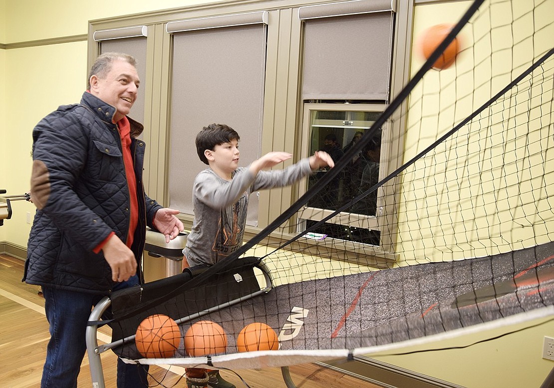 The holidays are all about family bonding, which is exactly what King Street, Rye Brook, resident Ernie Perez aims to do with his 9-year-old son Sebe by shooting hoops in the game room.