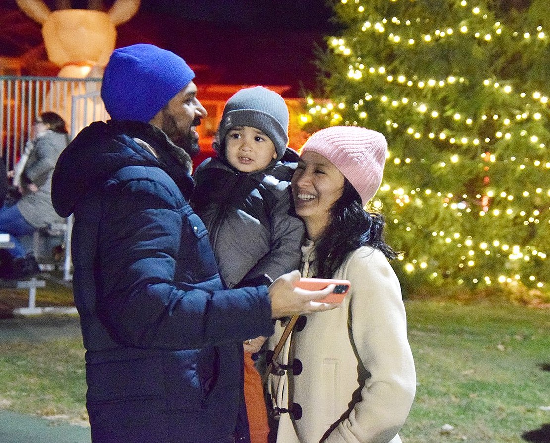 Vipul Nayi, his 3-year-old son Niam and wife Fany share a laugh after taking a family photo with the holiday tree in the background moments after it was ceremonially lit. The Valley Terrace residents are enjoying the night together at Rye Brook’s annual (barring the 2020 COVID year) Winterfest at Pine Ridge Park on Friday, Dec. 3.