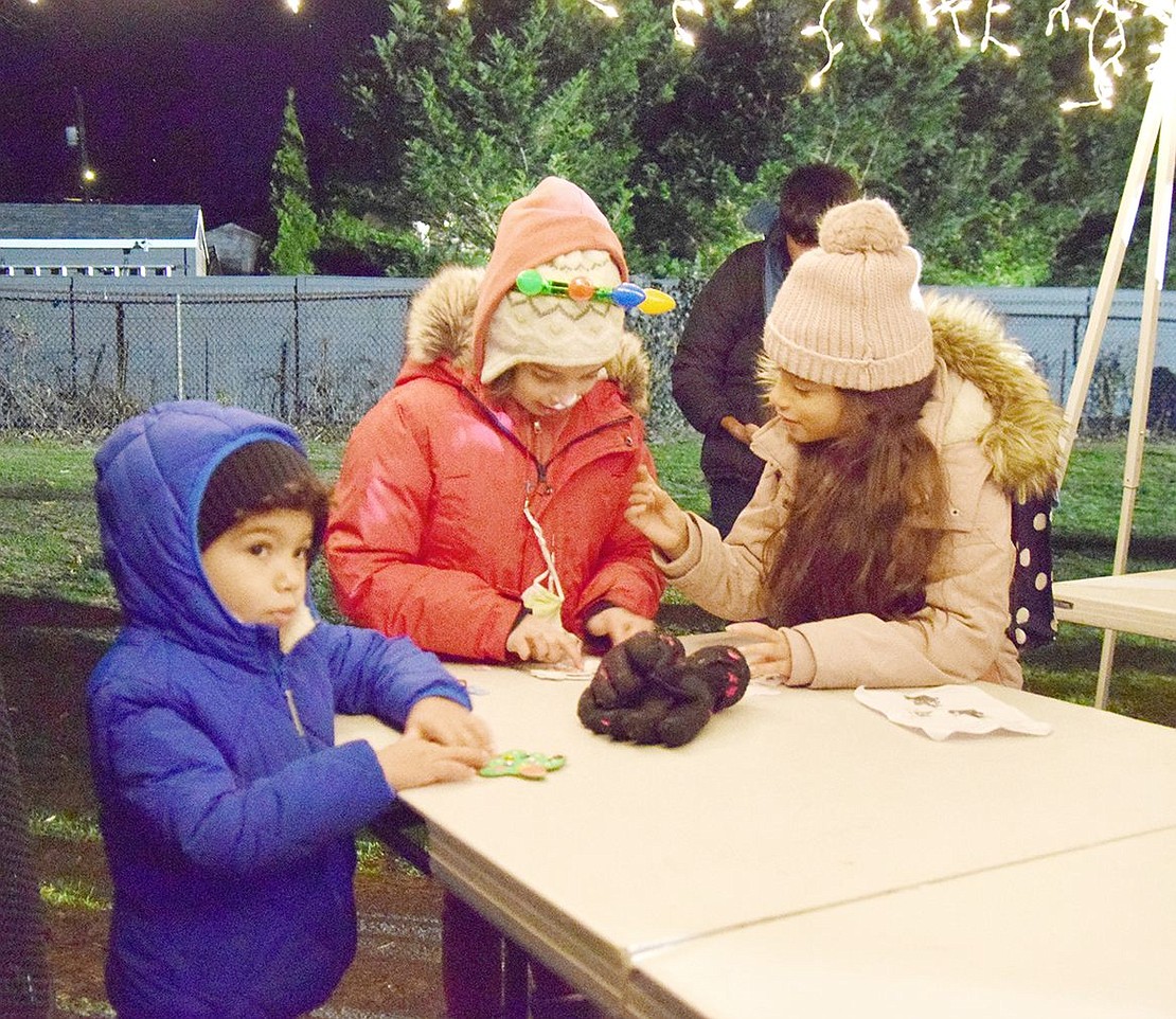 Great friends have names alike. Ridge Street Elementary School third-graders Olivia Morales (right) and Olivia Sileo, and 3-year-old Sebastian Morales, get ready to deck the halls at home by making holiday ornaments at the craft table.