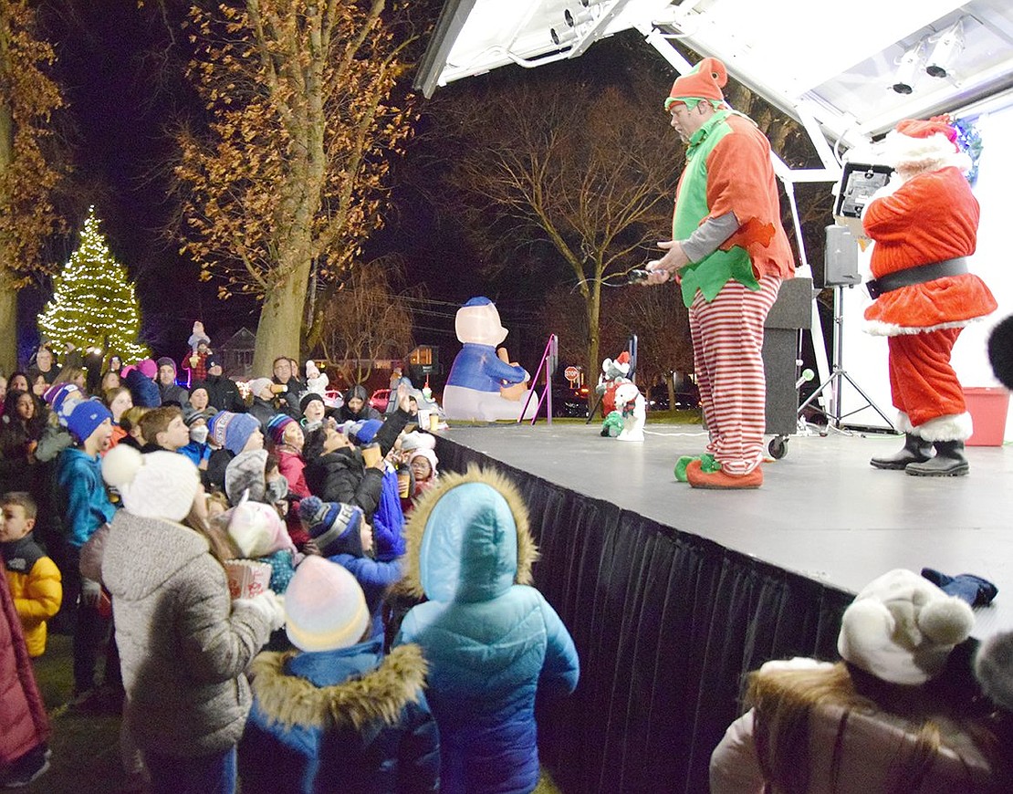 Children surround the stage in pure joy, eager to see what happens next on the Santa and Elf magic show performed by Pete and Chris Amusements.