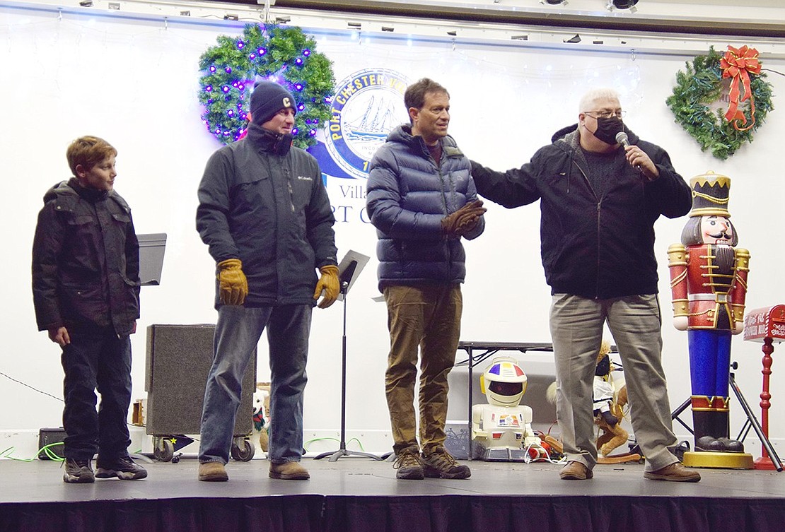 Ramping the crowd up, Village Administrator Chris Bradbury, Mayor Paul Rosenberg, Trustee Jason Klein and his son Alexander take the stage to kick off the tree lighting countdown.