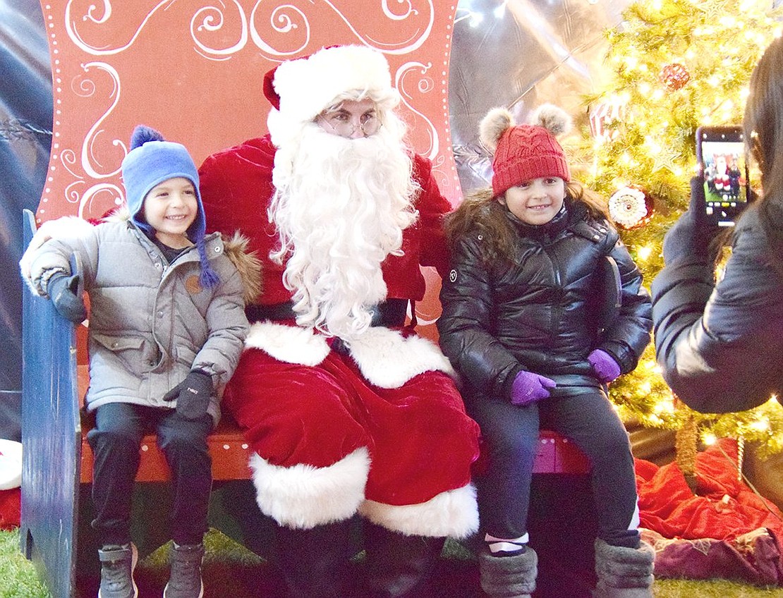 Maywood Avenue residents Ava Ianello, 7, and her 4-year-old brother Andrew are happy to sit with Santa Claus for a picture.