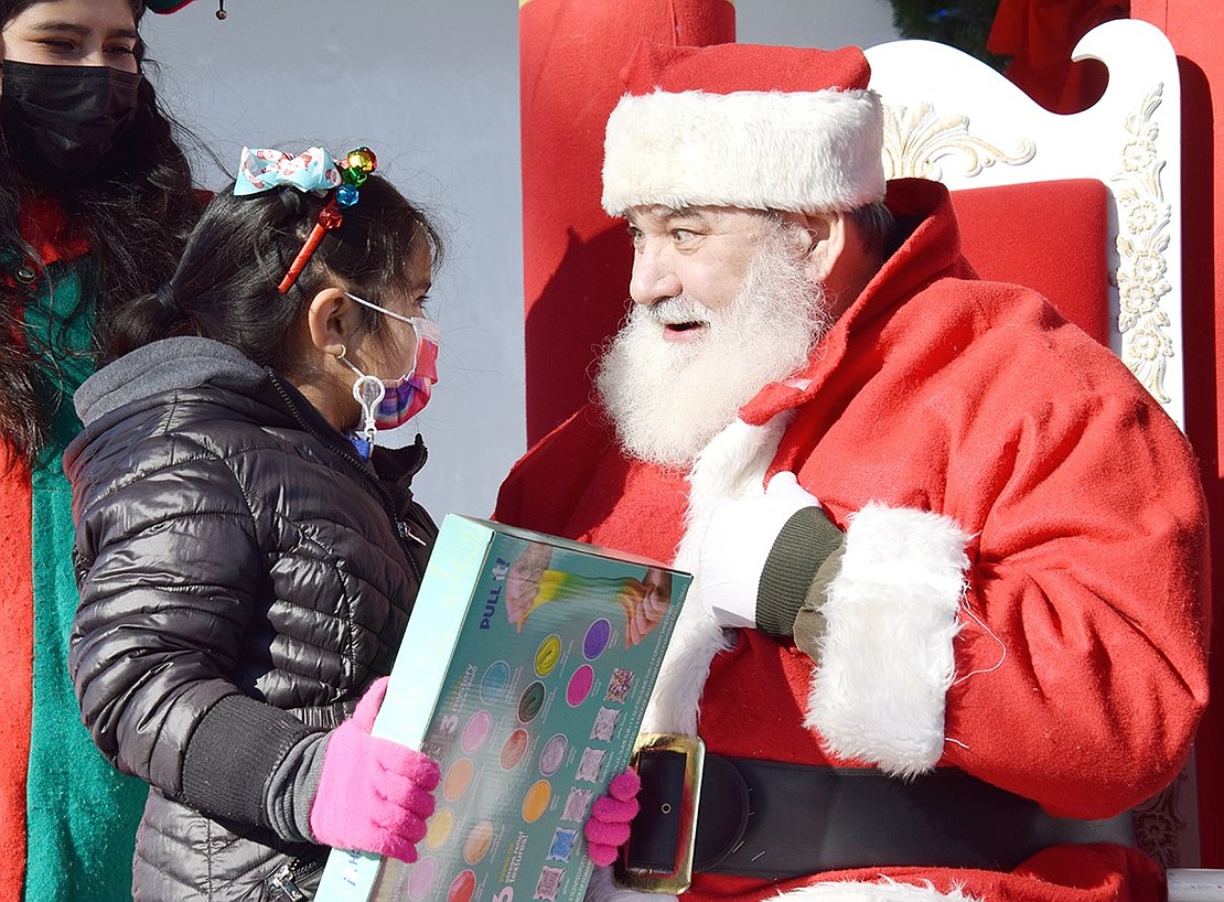 After picking out her Christmas present at Port Chester’s holiday parade and festival in Lyon Park on Sunday, Dec. 12, Park Avenue School kindergartener Allison Garcia shares some secrets with Santa Claus (who poses as Charlie Sacco during the rest of the year).