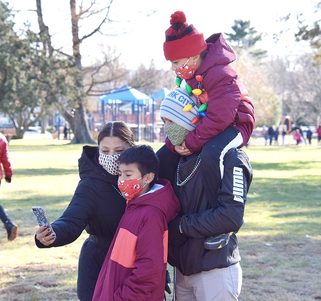 With the family adorned in holiday-themed face masks, Purdy Avenue resident Yaniva Hernandez pulls out a cell phone to commemorate the fun day with her three sons: Junior, 12, and José, 21, who carries 6-year-old Anthony on his shoulders.