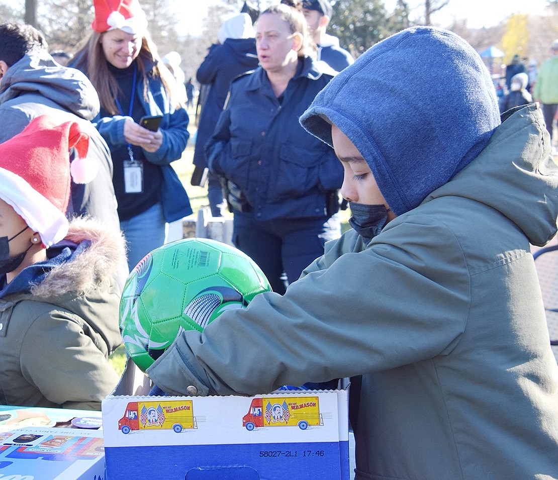 John F. Kennedy Elementary School fourth-grader Damien Ephraim tests out the available soccer balls before choosing the perfect one for his present.