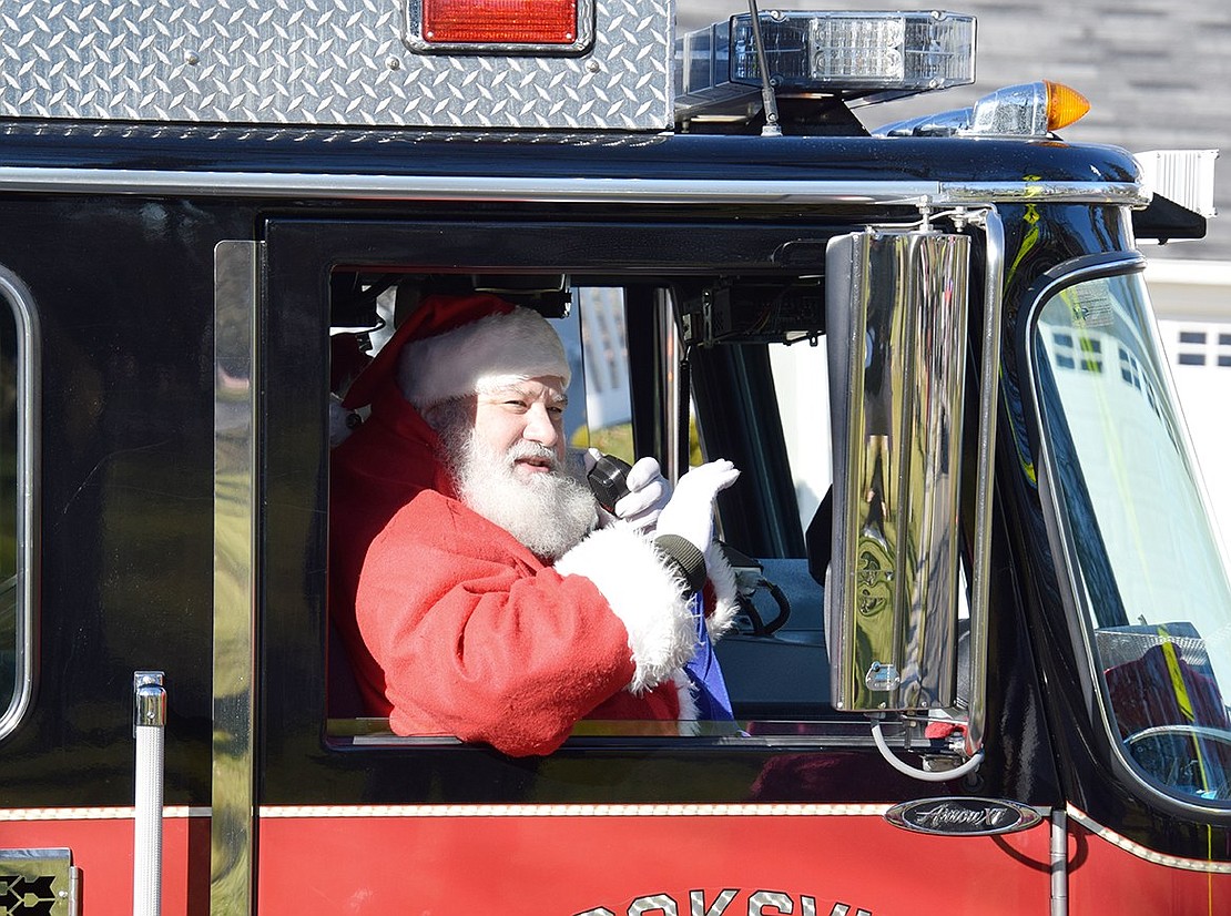 Making a spectacular entrance, Santa Claus pulls up to Lyon Park in style—riding in a Port Chester Fire Department engine.