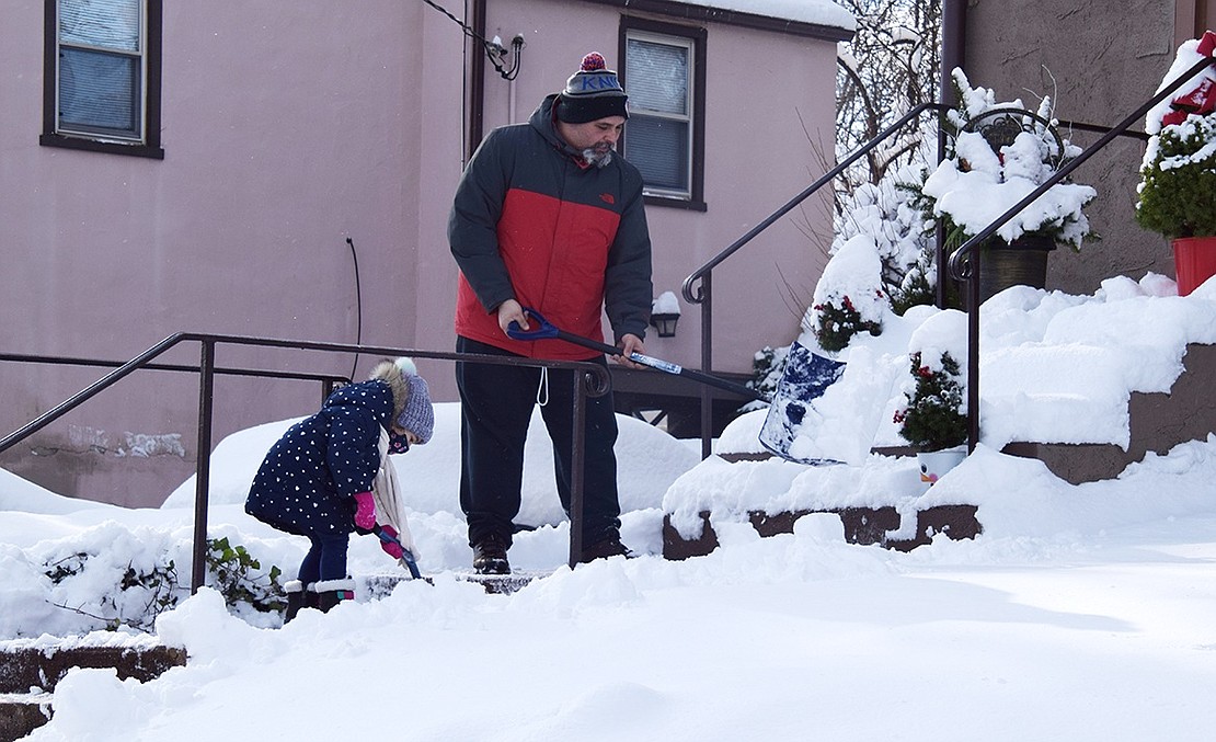 Al Altreche and his 3-year-old daughter Rey shovel snow off the front steps of their home at 74 Glen Ave. “I just got this place,” said Altreche. “It’s my first snow.”
