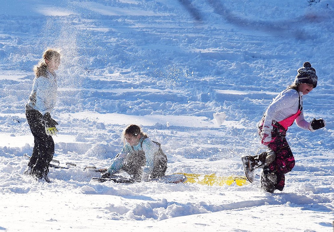 Girls engage in a snow fight at the base of the popular Crawford Park sliding hill.