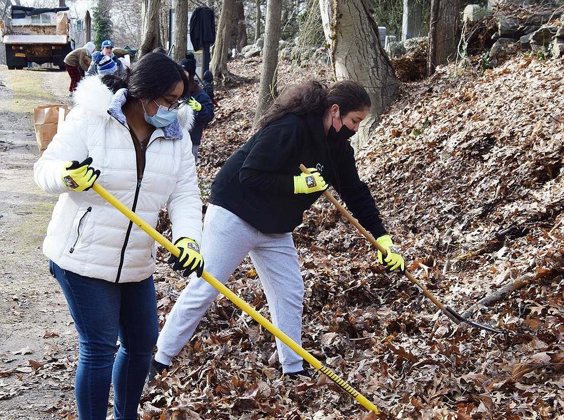 Valerie Espinoza and Shirleen Vazquez, both Port Chester High School sophomores and members of the school’s Key Club, which does service projects, rake leaves along the path leading into the African American Cemetery.