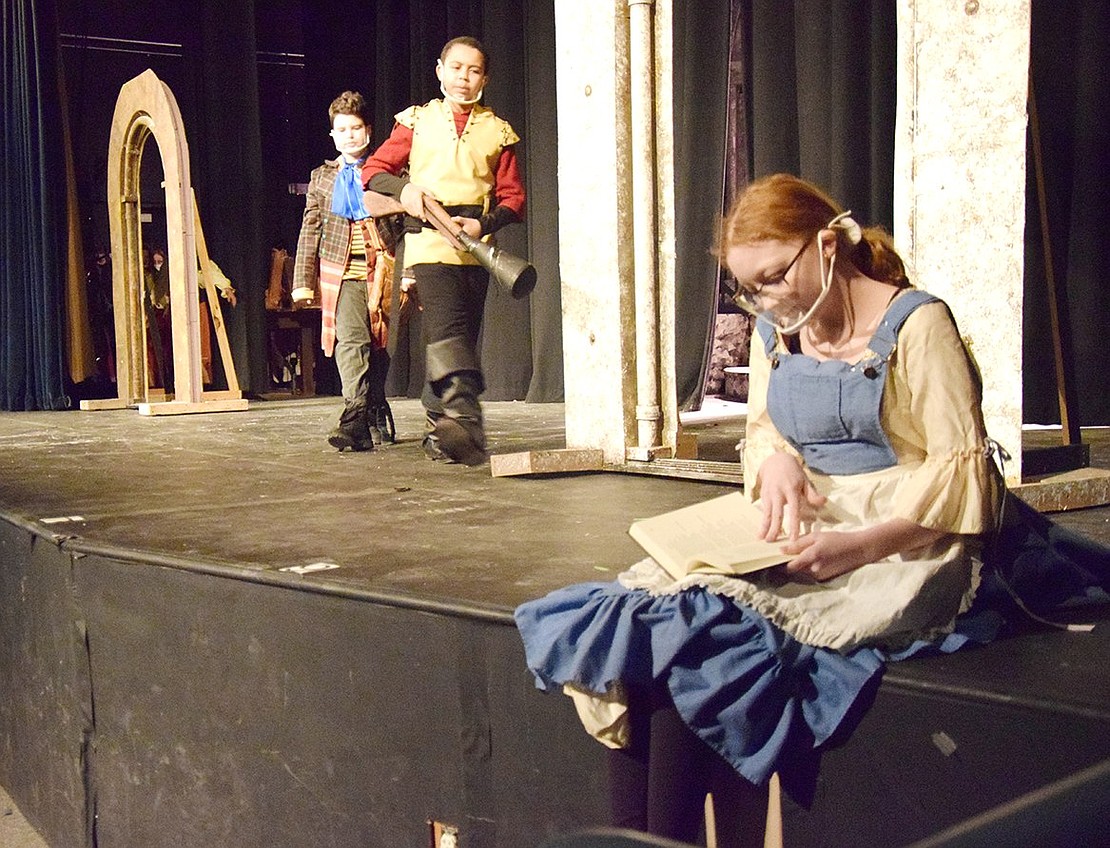 Minding her own business, Belle (played by Hannah Levine) quietly reads in the corner before Gaston (played by Simon Riley) approaches with Lefou (played by Andy Montvelisky) to disrupt while making his romantic intentions known.