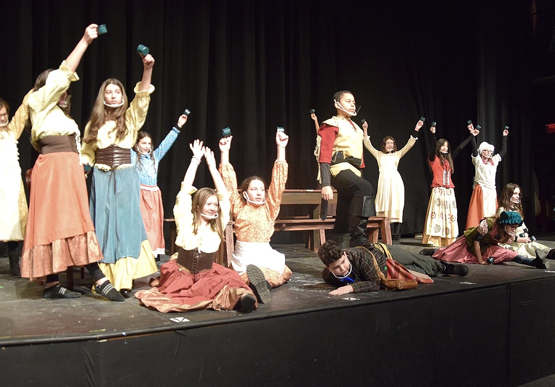 The “Beauty and the Beast” ensemble surrounds Gaston (played by Simon Riley) as he characteristically asserts dominance by stepping on his friend Lefou (played by Andy Montvelisky) at the end of the musical number “Gaston.”