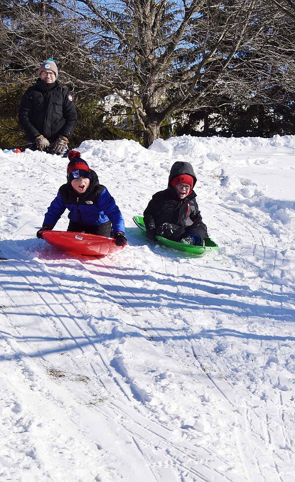 Dad watches as 8-year-old Jacob and 5-year-old Owen Mandell of Reunion Road slide down a hill off BelleFair Road on Sunday, Jan. 30, the bright, sunny day after the second major snowstorm of the season dropped about seven inches of precipitation in Rye Brook.