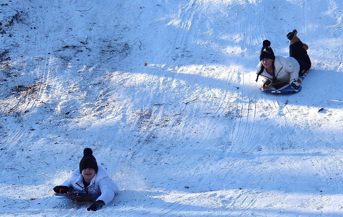 Katie Falk, above, and Lily Smith, both 13 and students at Blind Brook Middle School, were among the kids of all ages sliding down every hill, both steep and gradual, on both sides of Crawford Park on tubes, sleds and saucers Sunday afternoon.