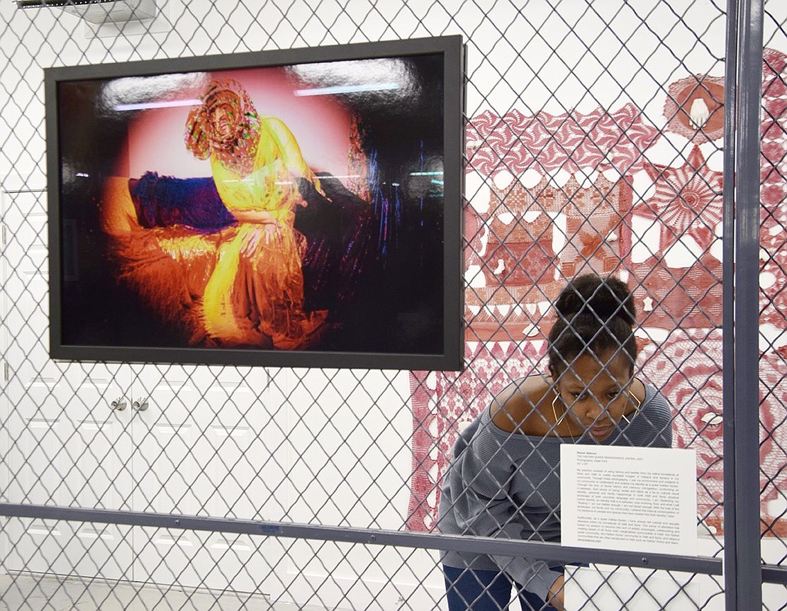 Brooklyn resident Winnie Arzu stands along the cage integral to the exhibit as a whole to read a detailed description about a collection of pieces. On the other side of the chain link fencing hangs “The Haitian Queer Renaissance,” a multimedia photograph by Steven Baboun, and she is shadowed by “A Joyful Keening,” a lace display by Port Chester-based artist Patricia Miranda who uses textiles to explore history, grief and women’s labor.