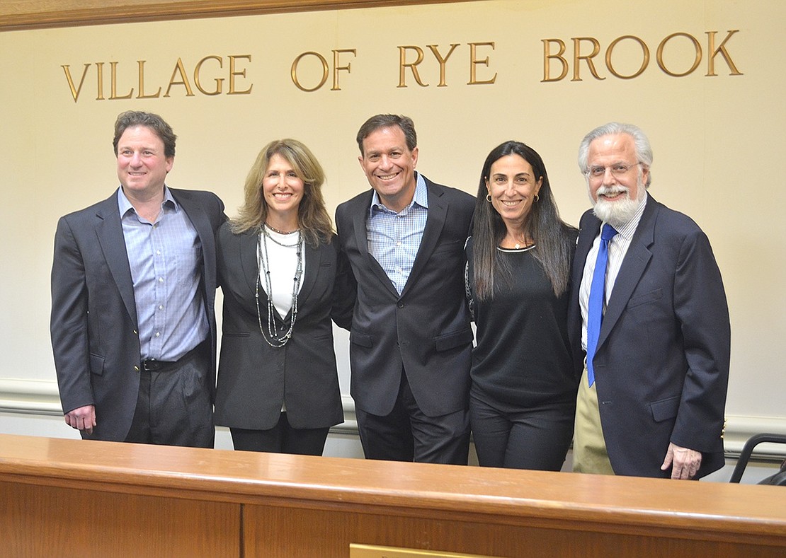 The village board outgoing Mayor Paul Rosenberg has served with for the past three years gathers under the Village of Rye Brook lettering above the dais in the meeting room at Village Hall one last time on Tuesday, Mar. 22 before Rosenberg’s final meeting. From left, Mayor-elect Jason Klein, Trustee Susan Epstein, Rosenberg, Trustee Stephanie Fischer and Trustee David Heiser.