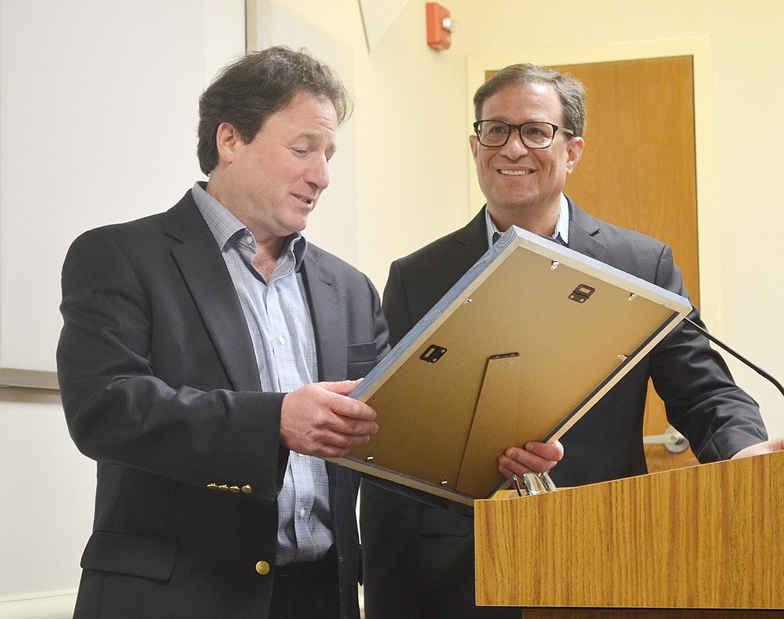 During the outgoing mayor’s recognition ceremony in a packed meeting room, Mayor-elect Jason Klein reads a proclamation from the Village of Rye Brook to Paul Rosenberg.