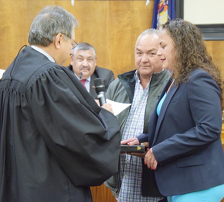With her hand on the Bible held by her father Ruben, new Trustee Juliana Alzate is sworn in by Rye Town Judge José Castaneda.