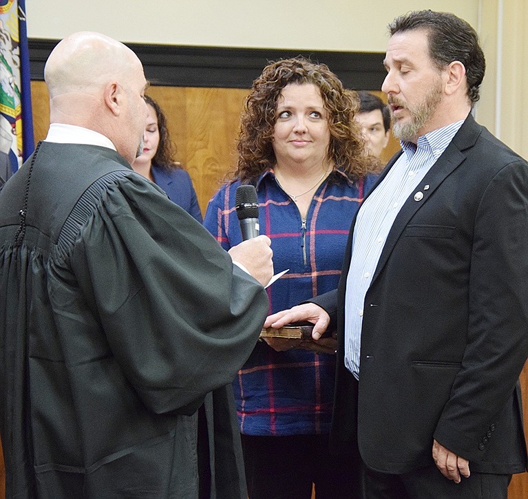 Rye Town Judge Jeffrey Rednick administers the oath of office to new Trustee Phil Dorazio while his wife Nicole holds the Bible and looks on.