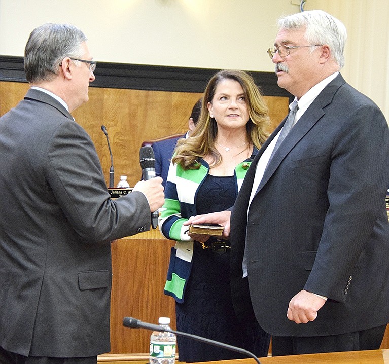 Trustee Bart Didden, accompanied by his wife Missy, takes the oath of office from former Port Chester Justice Peter Sisca at the start of his fourth three-year term. 