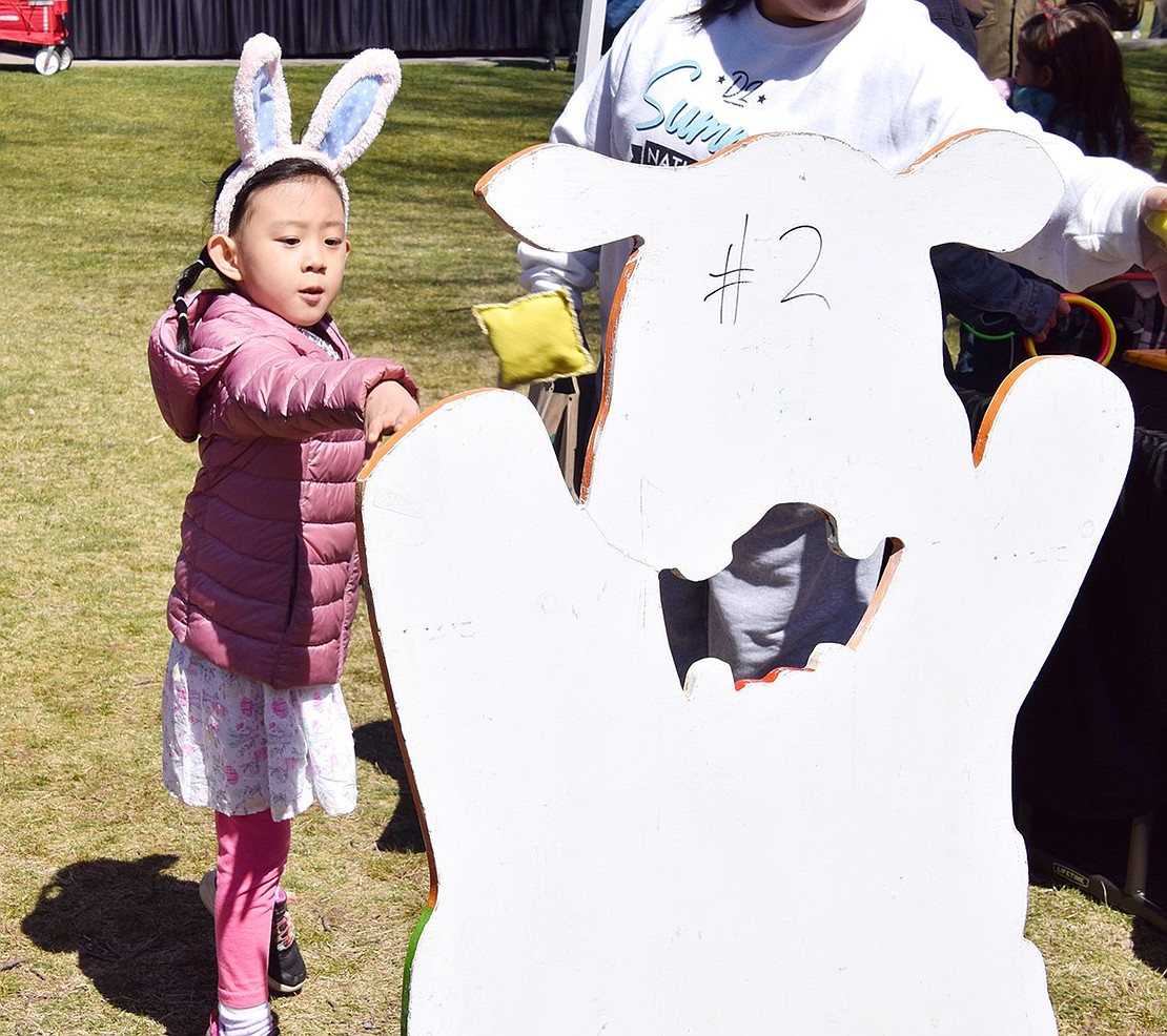 Rye resident Addy Su, 5, gives it all she’s got to try and land a sack into the hippopotamus’s mouth while playing the beanbag toss carnival game.