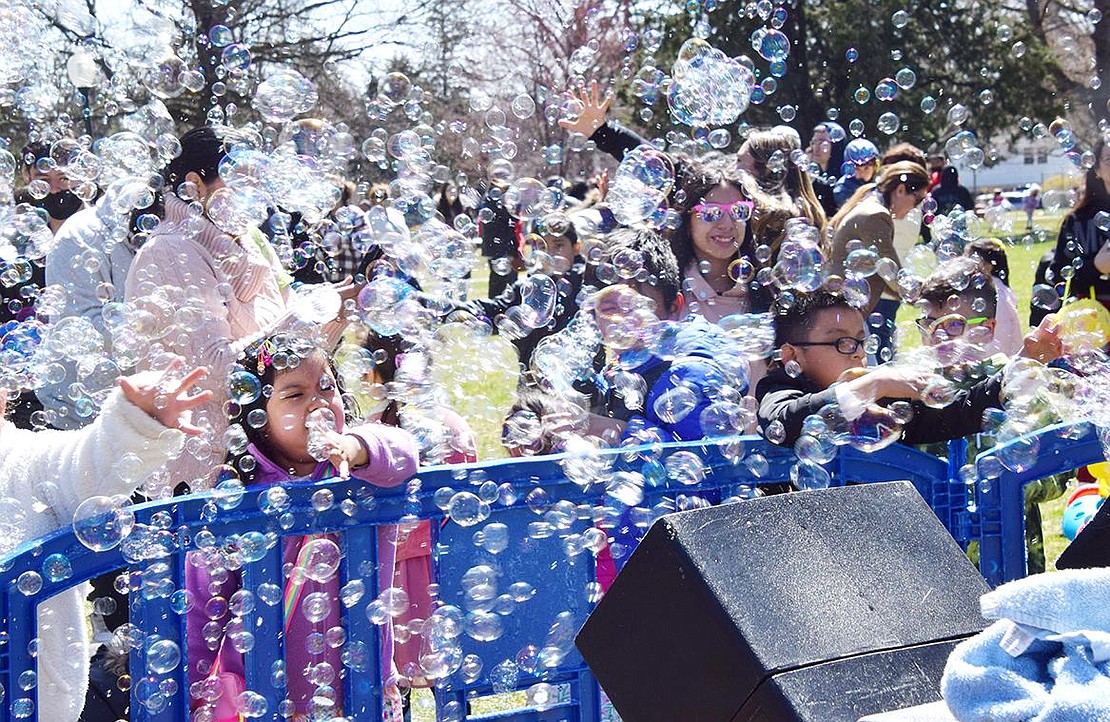 Children attending Easter in the Park rush the Bubble Bus to get as close as possible to the machines dispersing all the fun.