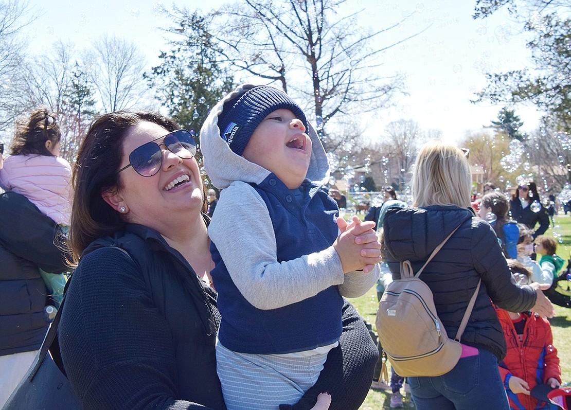 Comforted in the arms of his mother Sara Summa, a Port Chester Village clerk’s office assistant, 2-year-old Julian Maciel relishes the sun and bubbles at Lyon Park.