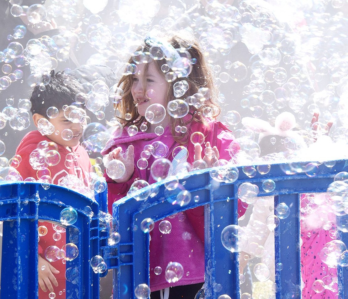 Navigating through a wall of suds and mist created by the Bubble Bus attraction, Port Chester resident Madeline Hering, a 7-year-old Resurrection School student, has some soapy fun while dancing to music.