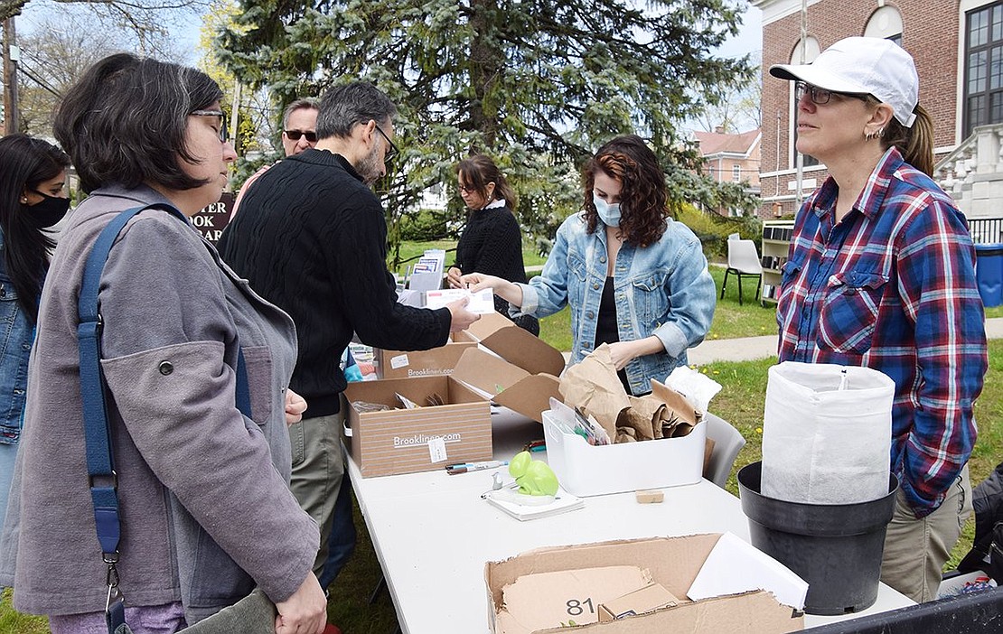 Maggie Nachlin of Putnam Drive in Port Chester and Bruno Melo of Betsy Brown Road in Rye Brook get sustainable planting advice and seeds from Port Chester Sustainability Committee member Kikki Short (foreground) and Rye Brook Sustainability Committee Chair Brigitte Dix at the Seed Swap and Giveaway in front of the Port Chester-Rye Brook Public Library Saturday morning, another Earth Week activity.