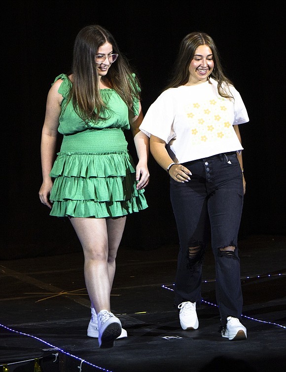 Seniors Carly Mallah and Sammie Rednick walk down the aisle in the Blind Brook High School auditorium wearing clothing from Mixology in the Rye Ridge Shopping Center during the Senior Fashion Show sponsored by the Student Senate as a fundraiser for Corporate Angel Network on Friday, Apr. 22.