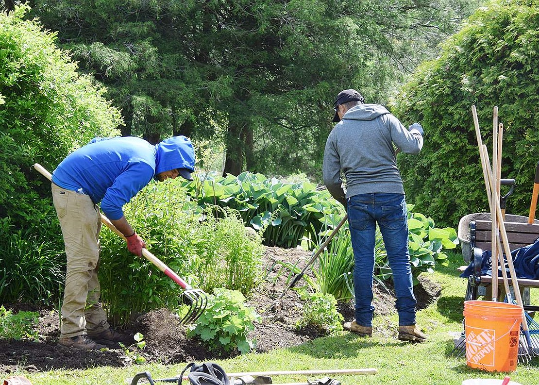 Two residents till the soil in one of the many beds at Crawford Park.