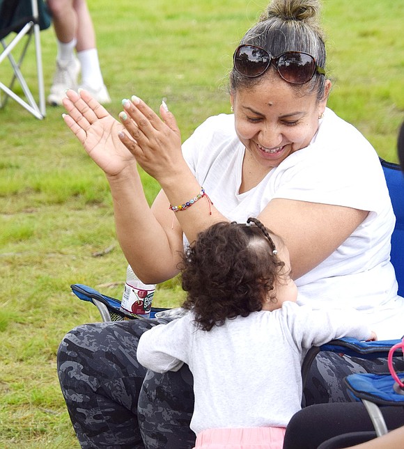 Port Chester resident Sandra Sanchez claps along to the Latin tunes while having fun and bonding with her 15-month-old granddaughter Nataly, also of Port Chester.