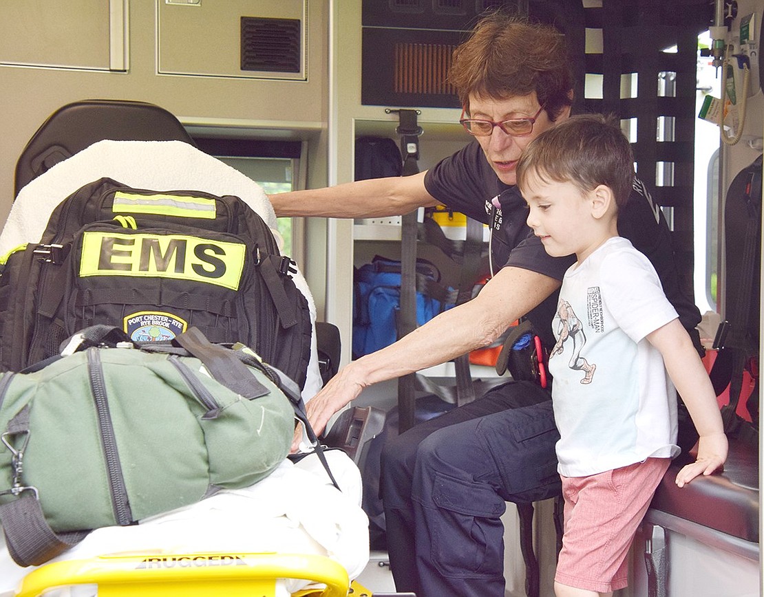 Port Chester resident Mason Monaim, 3, learns all about life-saving equipment from Sally Peterson of the Port Chester-Rye-Rye Brook EMS during an ambulance demonstration at the birthday party.