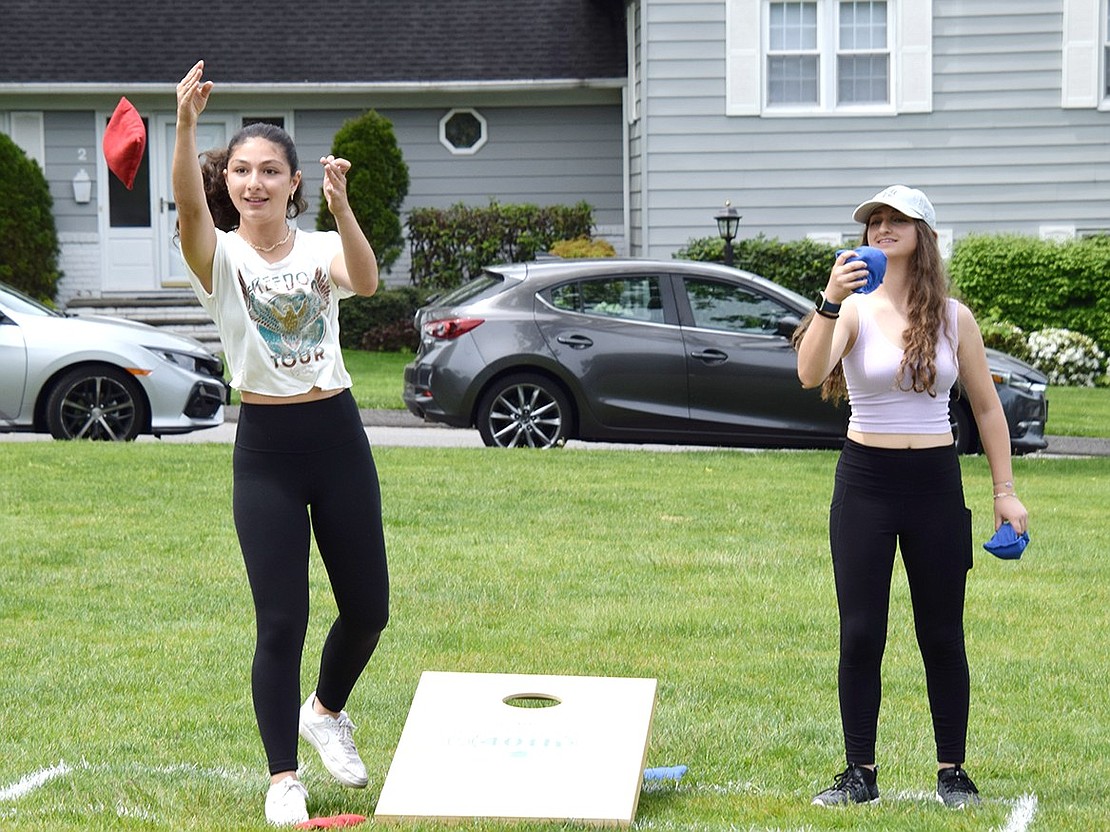 Blind Brook High School freshmen Natalia Vivenzio (left) and Sophia Morlino give the task at hand all their focus as they try to perfect their cornhole game.