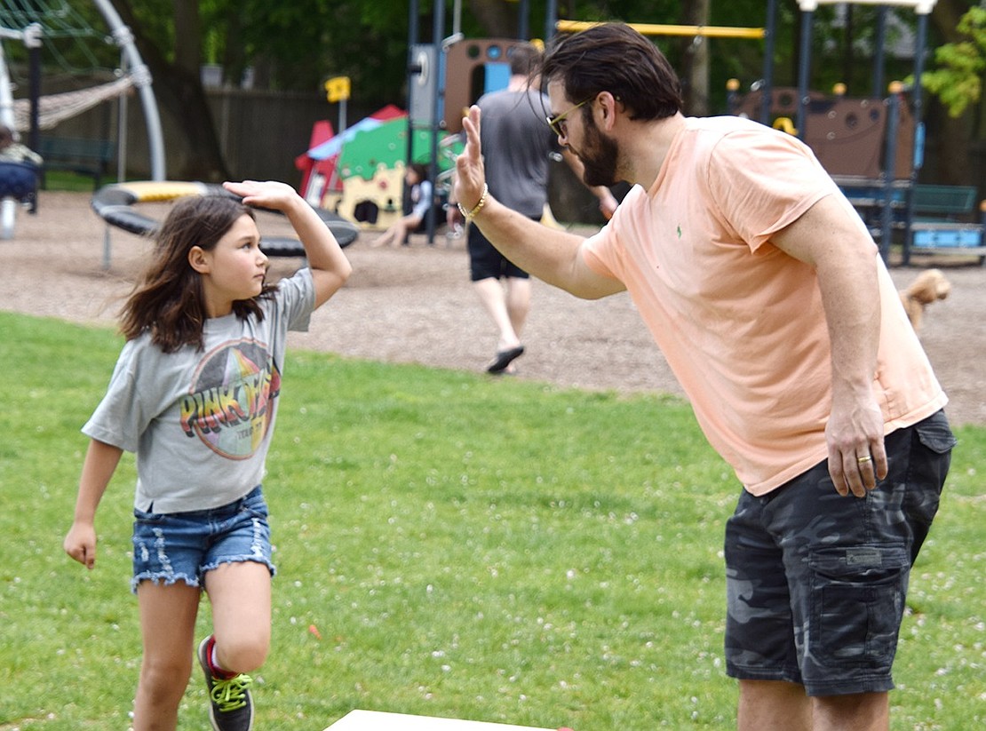 In a sweet bonding moment, Ridge Street Elementary School first-grader Edie Georges gives her father Chris an intense high-five when she makes a good shot after he took some time to show her the ropes.