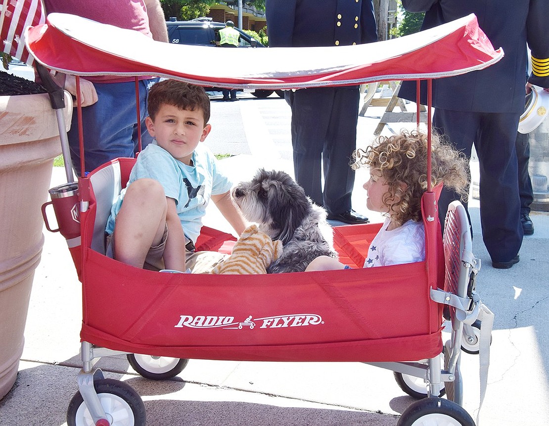 It gets hot when standing under the sun for too long, but Rye Brook residents Caden Krebs, 5, his sister Tori, 3, and their Havanese Ollie beat the heat by relaxing in their shaded red wagon during the Memorial Day ceremony.