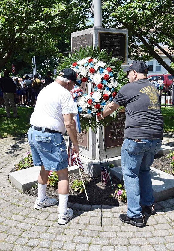 A tradition every year, Vietnam veterans Dominick Mancuso of Port Chester and Peter Sileo of Rye Brook place a memorial wreath at the flagpole monument recognizing local veterans who died during World War II and the Korean War.