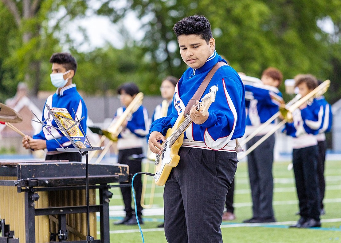 Eighth grade mallet player Andrew Abraham (left) and eighth grade bass guitarist Jordan Rivera play in the foreground with the rest of the Port Chester Middle School 7th and 8th grade band behind them.