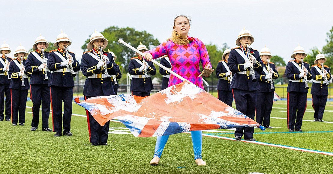 Color Guard member Angelia Fallanca maneuvers her flag as the Port Chester High School Marching Band clarinetists play behind her during a recreation of the band’s fall field show.